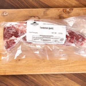 Vacuum-sealed pork tenderloin on a wooden cutting board; label reads 'Tenderloin (pork)'.