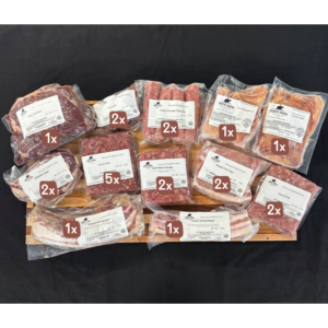Assorted vacuum-sealed meat cuts and sausages arranged on a wooden board with quantity labels (1x, 2x, 5x).
