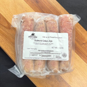Vacuum-sealed package of four bratwursts from Fred's Farm labeled 'Bratwurst Grillers 4/pk,' net weight 1.04 lb, on a wooden surface.