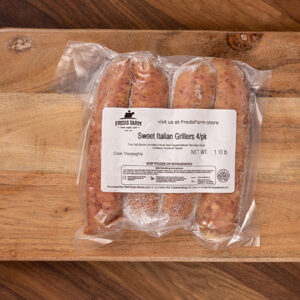 Vacuum-sealed package containing four Sweet Italian grillers sausages on a wooden cutting board; label shows Fred's Farm.