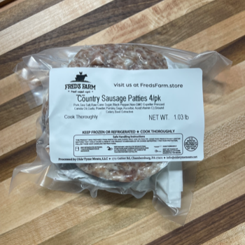 Frozen package of Fred's Farm Country Sausage Patties (4 patties, 1.03 lb) in plastic wrap on a wooden surface.