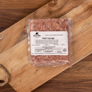 Vacuum-sealed maple sausage on a wooden cutting board, Far from the label visible on the package (brand: Fred's Farm).