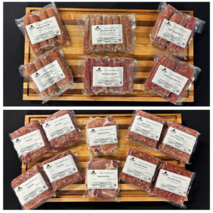 Two wooden boards filled with vacuum-sealed packages of various raw meats with white labels on black background.