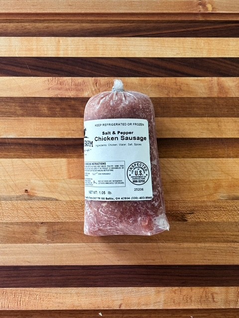 Vacuum-sealed Salt & Pepper Chicken Sausage on a striped wooden cutting board (weight 1.05 lb).